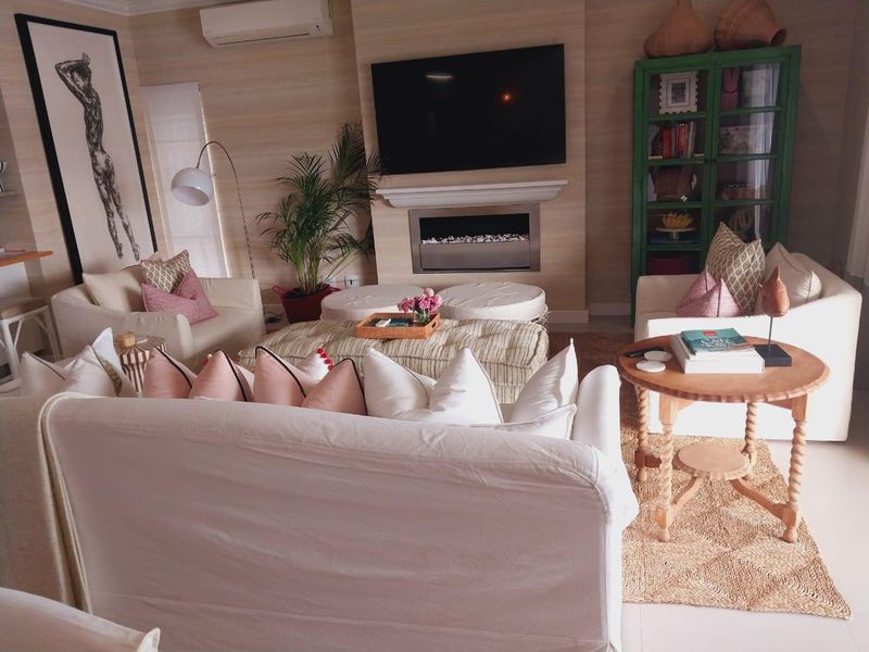 A comfortable living room featuring a modern built-in fireplace, wall-mounted air conditioning, and neutral wall finishes.