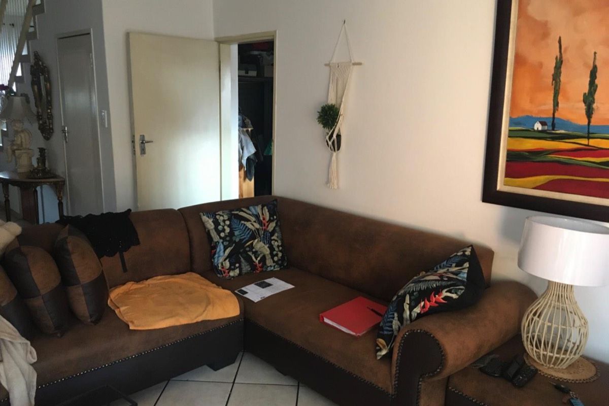 A living room area featuring tiled flooring and access to an adjacent room, providing a functional space for relaxation.