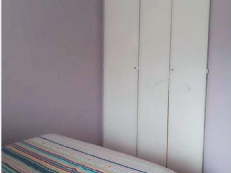 A bedroom featuring a built-in wardrobe with white doors and coving detail.