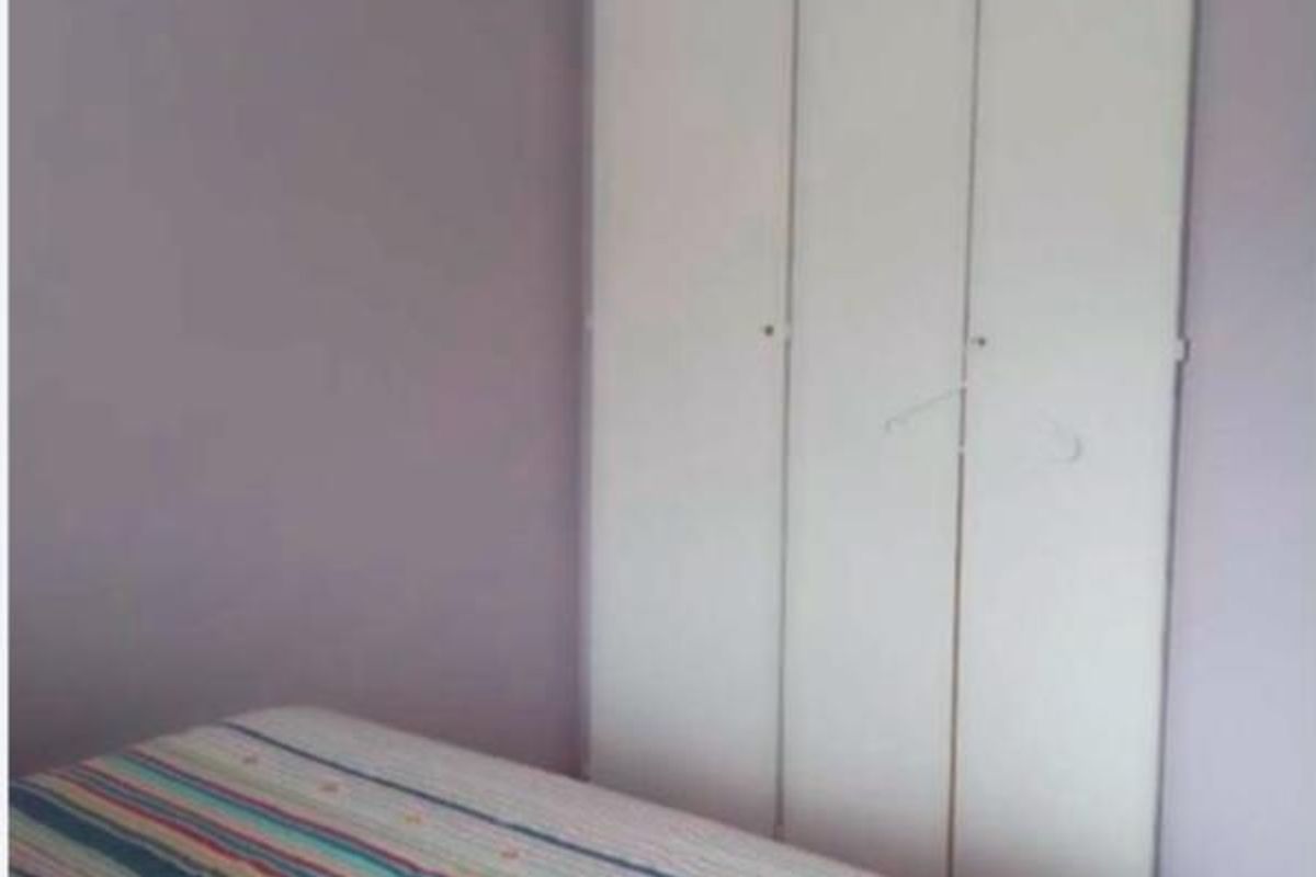 A bedroom featuring a built-in wardrobe with white doors and coving detail.