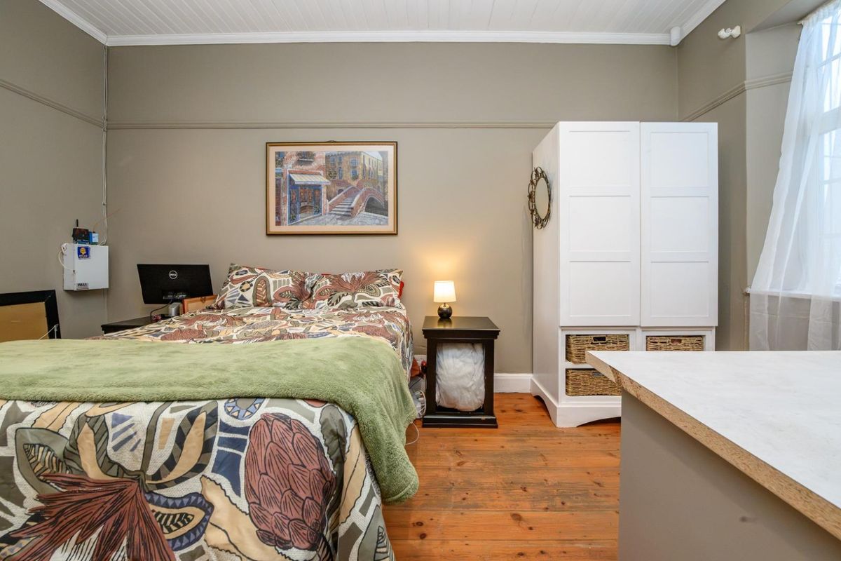 A bedroom featuring original timber flooring, a tongue and groove ceiling, and classic picture rail detailing.