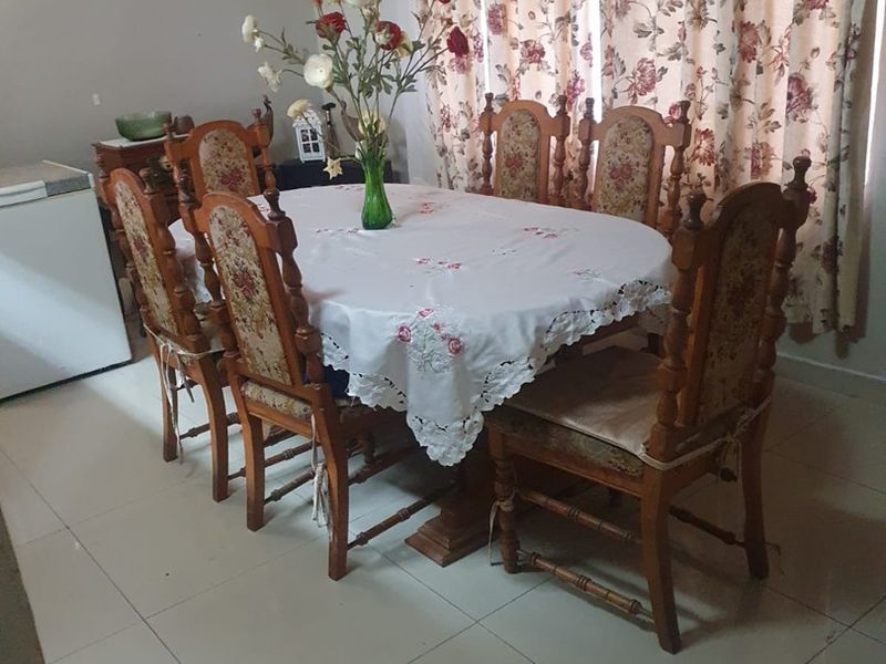 A dining room featuring tiled flooring and a timber ceiling, providing a functional space for family meals.