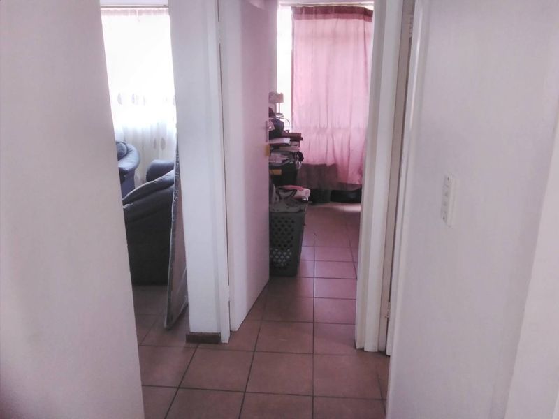 A functional hallway with tiled flooring providing access to adjacent rooms within the apartment.