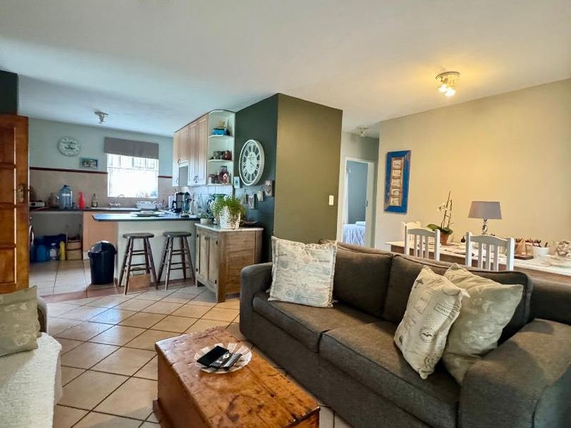 Open plan living area featuring tiled flooring, a dining space, and a functional kitchen with built-in cabinetry and counter space.