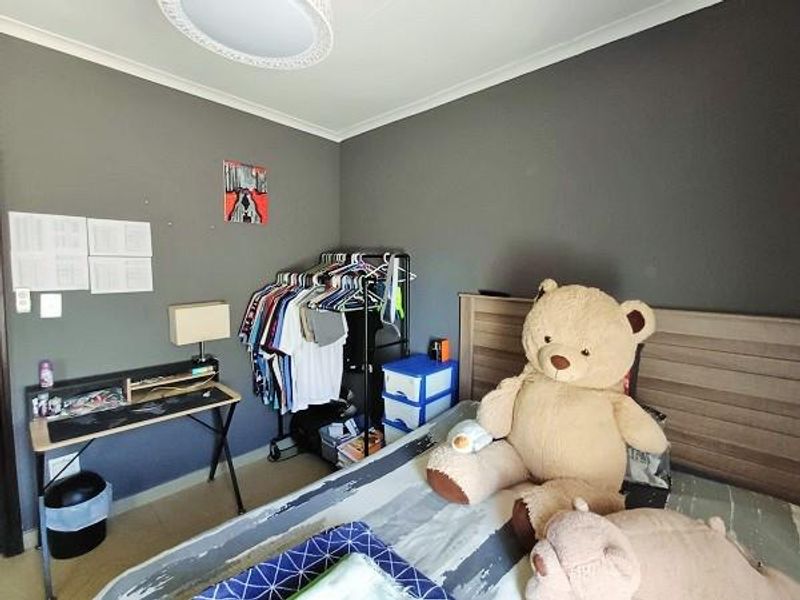A bedroom featuring dark grey walls, tiled flooring, and a central ceiling light fixture.
