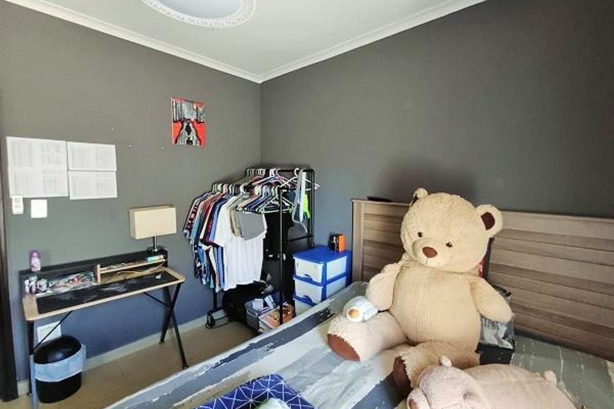 A bedroom featuring dark grey walls, tiled flooring, and a central ceiling light fixture.