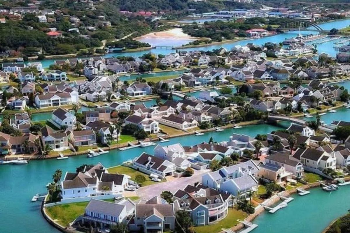 An aerial view of a residential canal estate featuring waterfront properties with private jetties and landscaped surroundings.