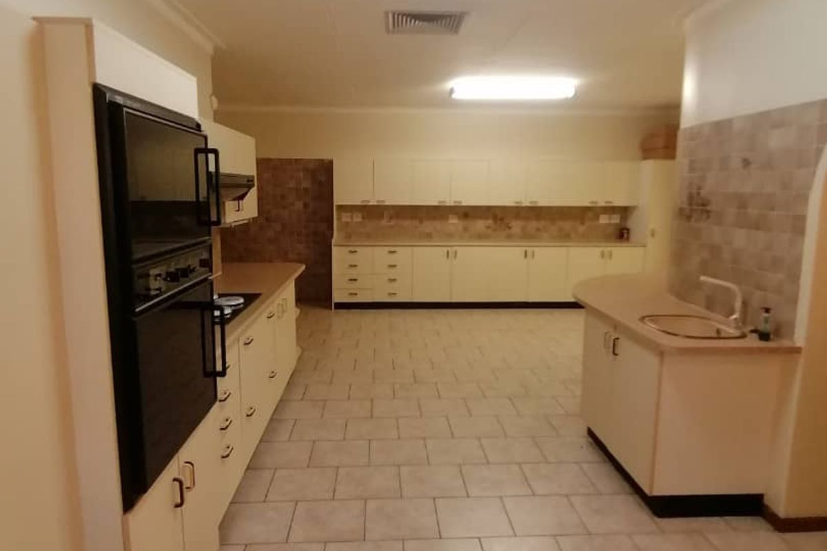 Spacious kitchen featuring extensive built-in cabinetry, integrated wall oven, and tiled flooring, offering a functional layout with ample storage and workspace.