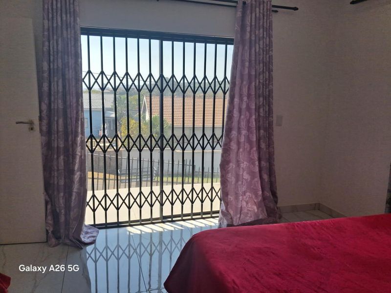 Bedroom featuring tiled flooring and a sliding glass door with a security gate providing access to the exterior.