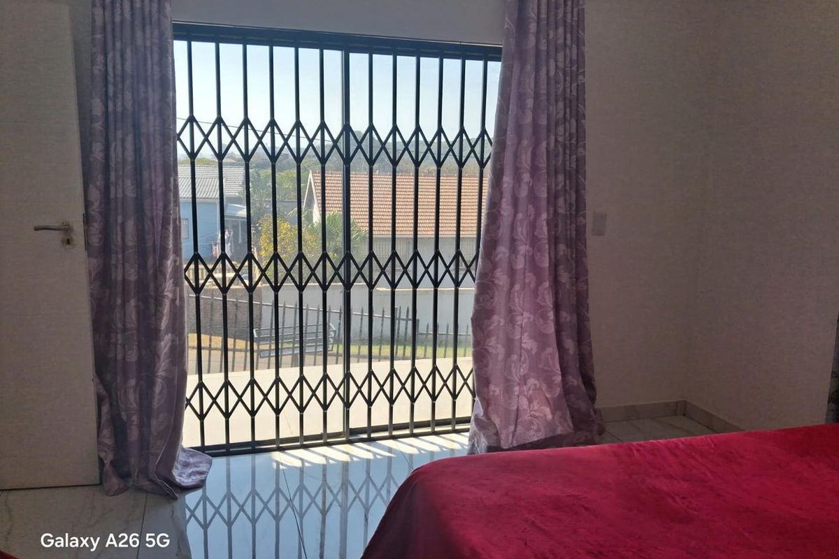 Bedroom featuring tiled flooring and a sliding glass door with a security gate providing access to the exterior.