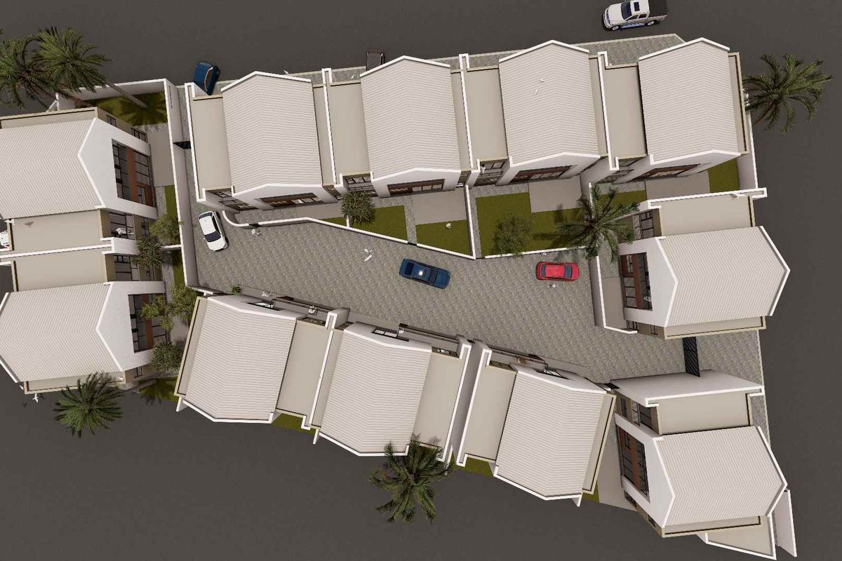 An aerial view of a townhouse complex showing the layout of multiple units, paved driveway, and landscaped garden areas.