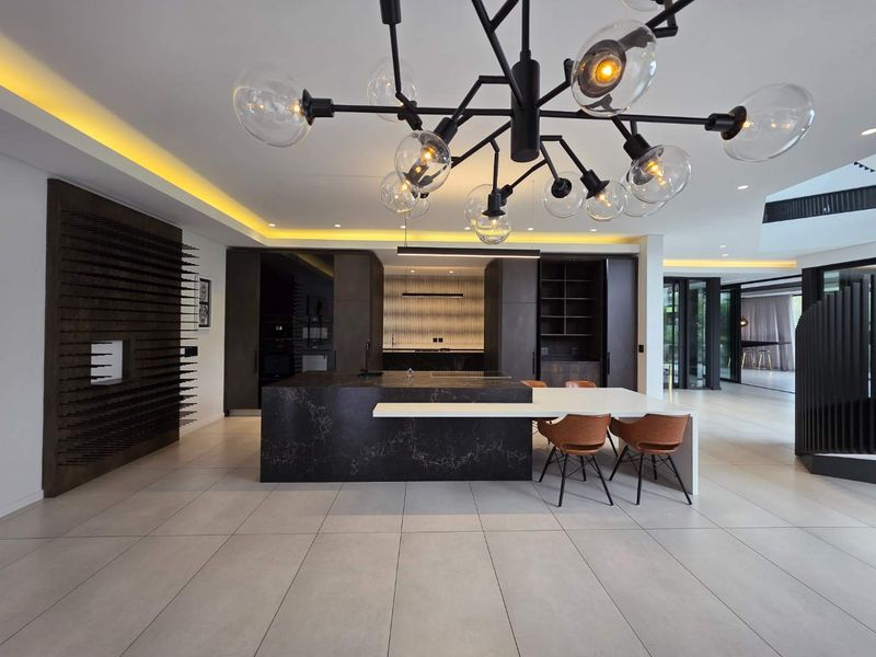 Modern open-plan kitchen featuring a large stone island, sleek built-in cabinetry, recessed lighting, and high-end finishes in a spacious, contemporary living area.
