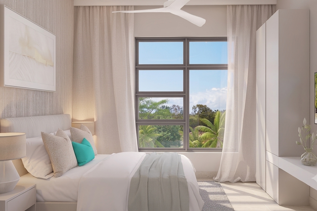 A modern, well-lit bedroom featuring a built-in wardrobe, integrated desk, and ceiling fan, with large windows offering a pleasant outdoor view.