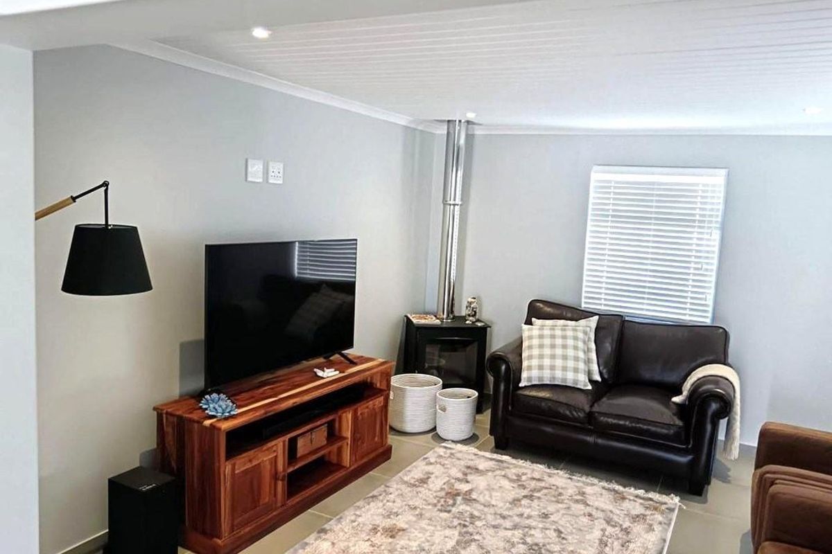 A well-maintained living room featuring a wood-burning fireplace, tiled flooring, and recessed lighting, creating a comfortable and functional space.
