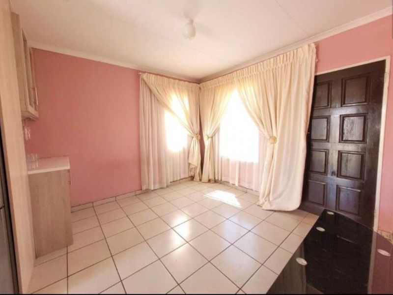 A living area featuring tiled flooring, coved ceilings, and a traditional panelled door, offering a functional space ready for modern updates.