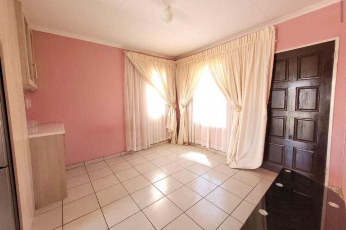 A living area featuring tiled flooring, coved ceilings, and a traditional panelled door, offering a functional space ready for modern updates.