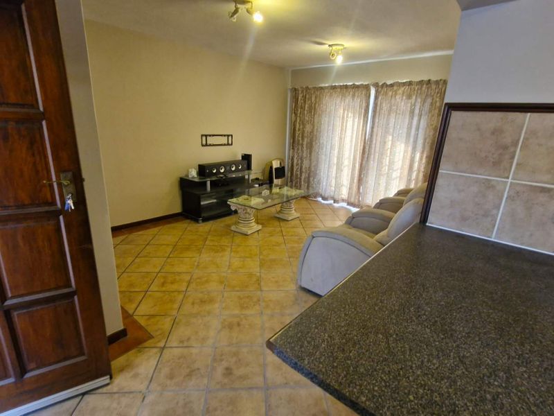 Open plan living area featuring tiled flooring, granite kitchen countertops, and sliding glass doors leading to the exterior.