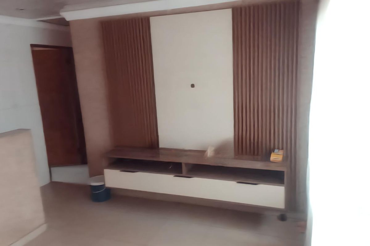 Living room featuring a modern built-in media console with decorative slatted wood wall paneling and neutral tiled flooring.