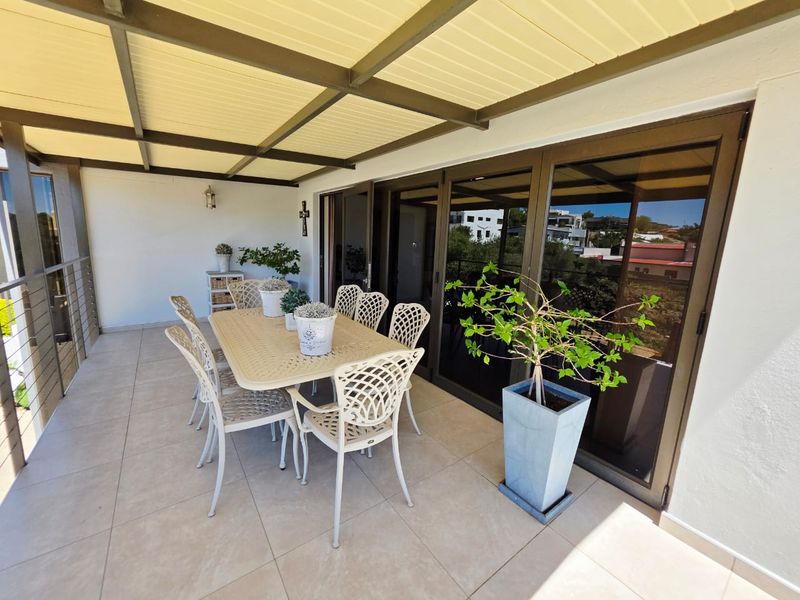 A spacious covered patio featuring tiled flooring and large sliding glass doors, providing a seamless transition between indoor and outdoor living areas.