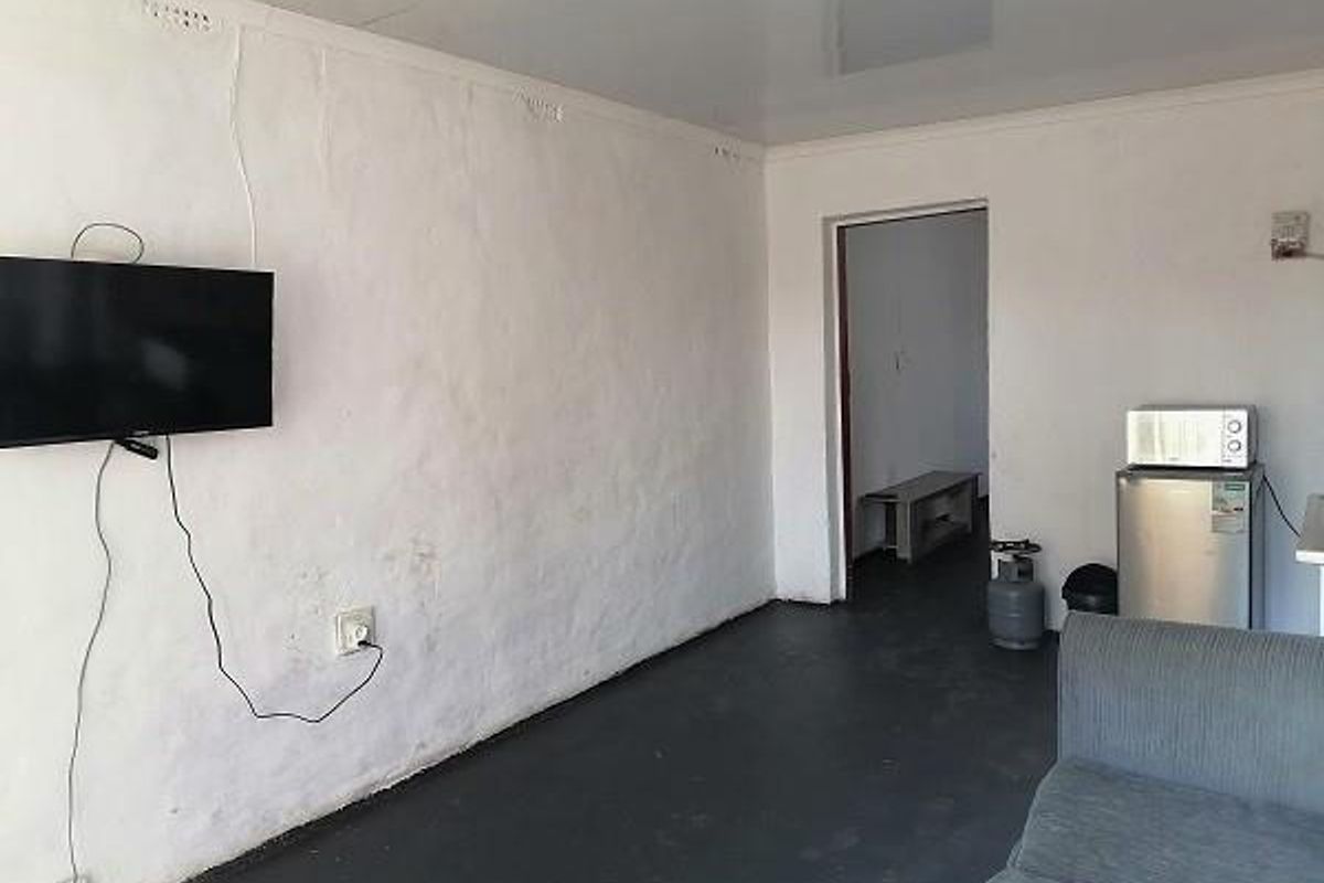 A simple living area featuring a glossy ceiling and textured walls, providing a functional space with potential for cosmetic updates.