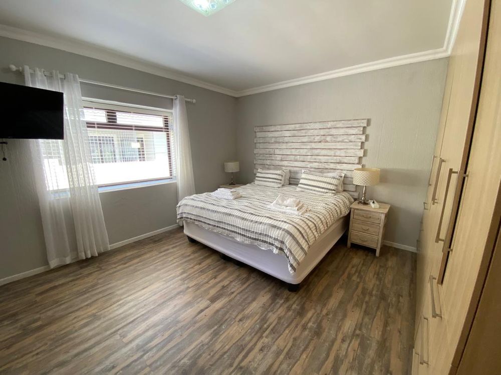 Ground floor, bedroom 1 with built-in cupboards, TV and en-suite bathroom. 