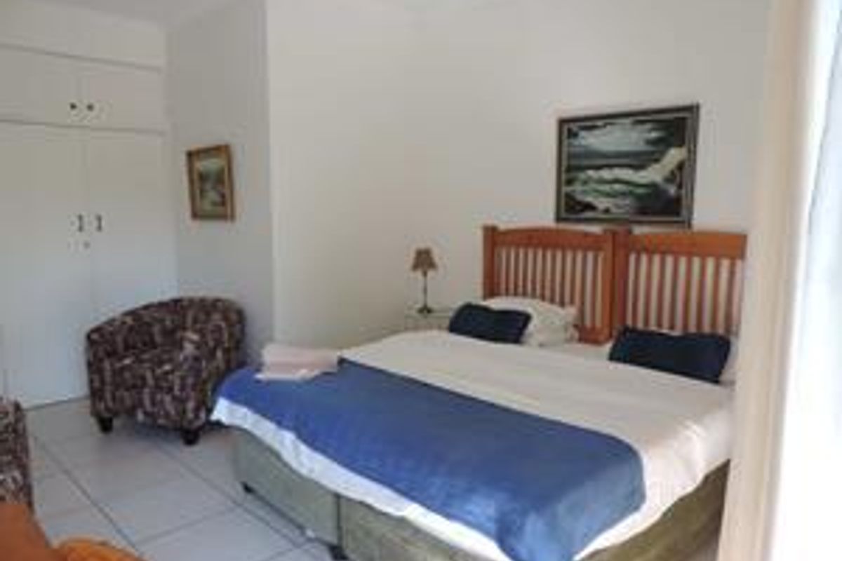 A bedroom featuring built-in cupboards and tiled flooring.