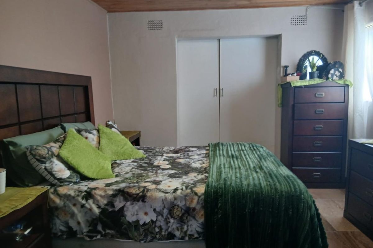 A bedroom featuring built-in cupboards and a timber-paneled ceiling, offering a functional and comfortable living space.