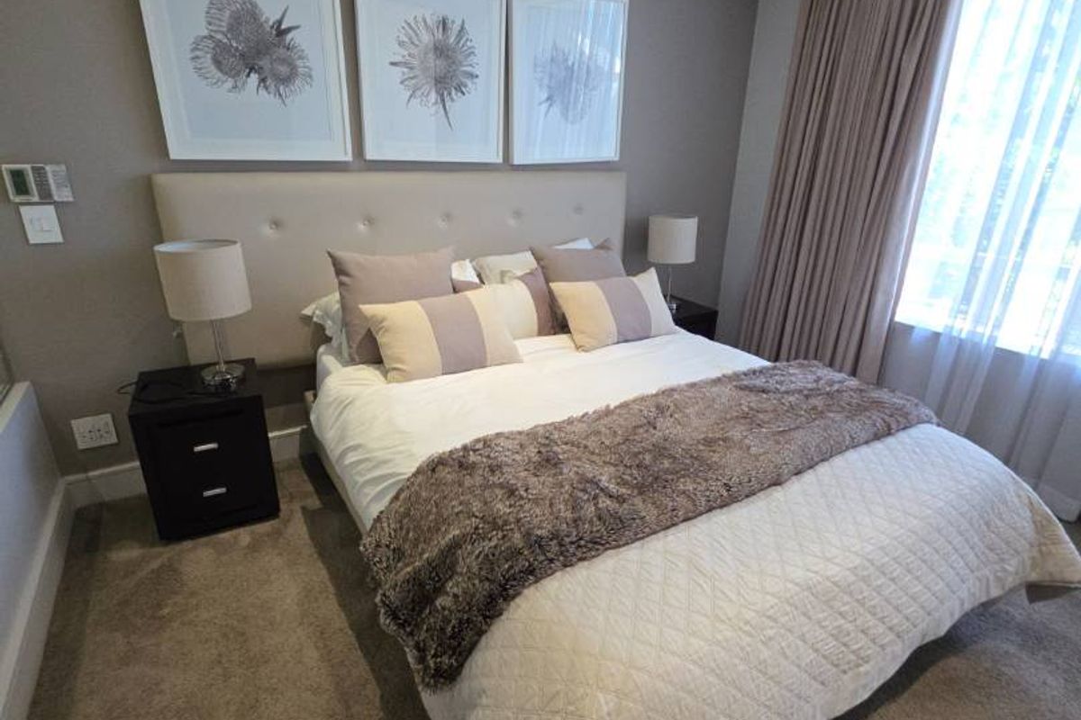 A well-maintained bedroom featuring neutral wall tones, recessed ceiling lighting, integrated air conditioning, and plush carpeting.