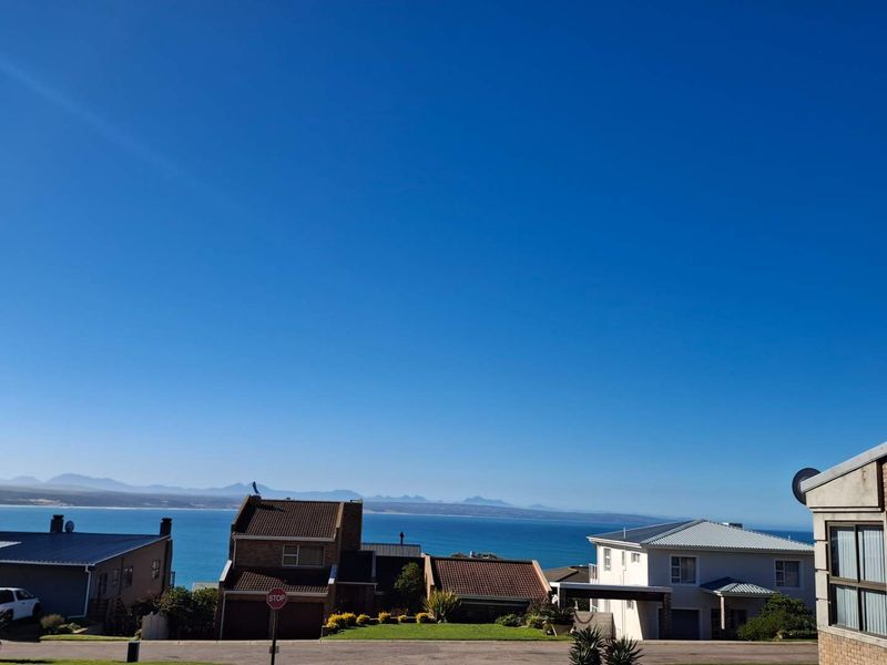 A scenic elevated view overlooking the surrounding residential neighborhood with a clear outlook towards the ocean and distant mountain range.