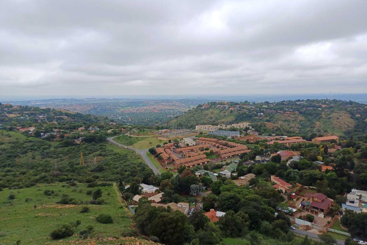 An elevated aerial view showcasing the surrounding landscape, residential neighborhood, and natural terrain of the area.