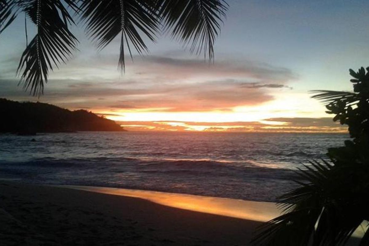 A scenic sunset view over the ocean, showcasing the natural landscape and coastal surroundings of the property.
