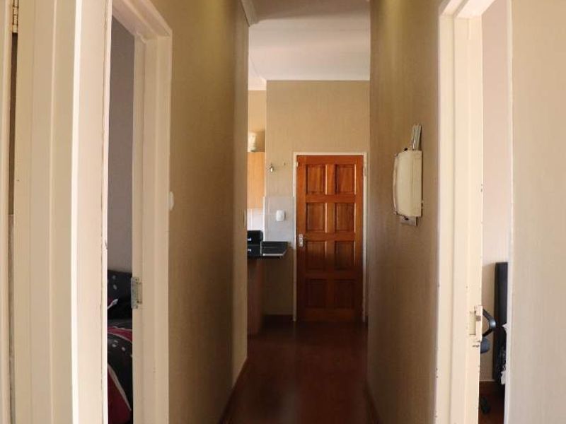 A functional hallway featuring laminate flooring and neutral wall tones, providing access to multiple rooms within the townhouse.