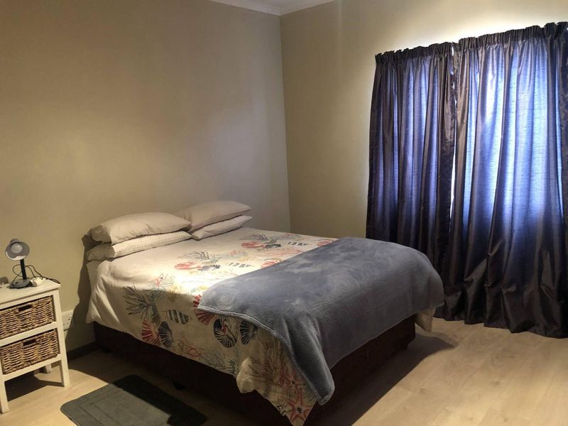 A standard bedroom featuring light-toned laminate flooring and neutral wall finishes, providing a functional and comfortable sleeping space.
