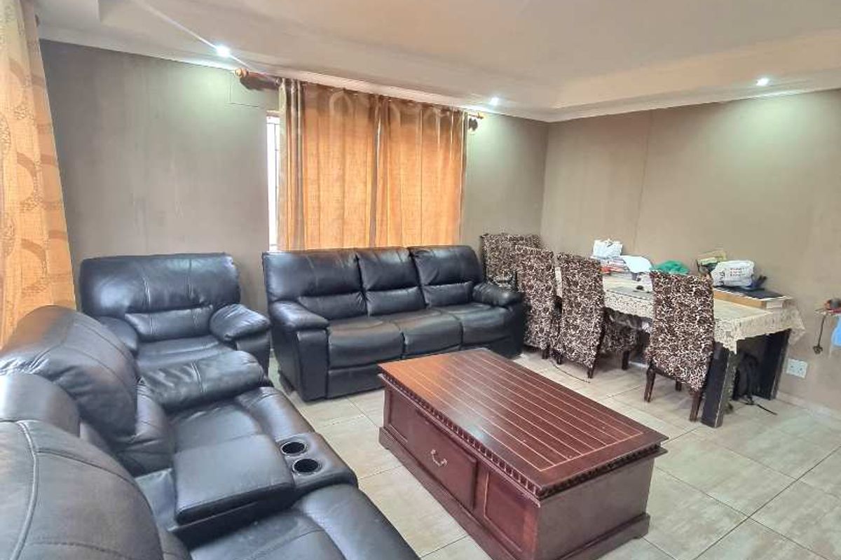 Spacious living area featuring large format floor tiles, recessed ceiling lighting, and neutral wall finishes, providing a comfortable and functional space for relaxation.