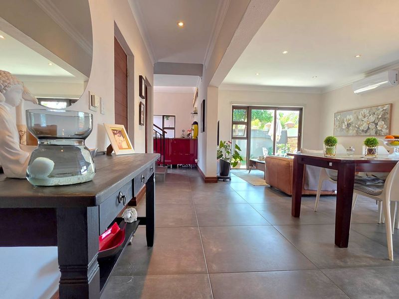 Spacious open-plan living and dining area featuring large format floor tiles, recessed lighting, and direct access to the outdoor patio through sliding glass doors.
