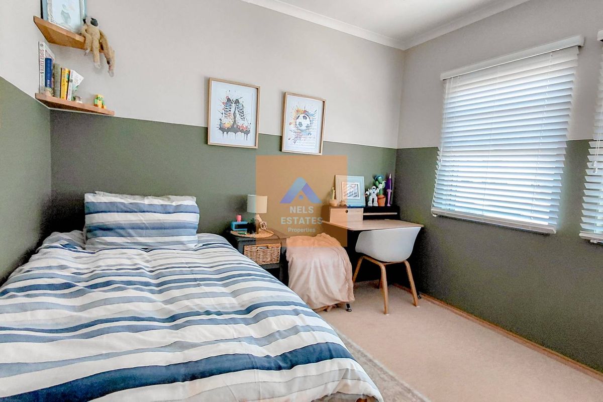 A well-maintained bedroom featuring neutral carpet flooring, two-tone painted walls, and fitted venetian blinds for natural light control.