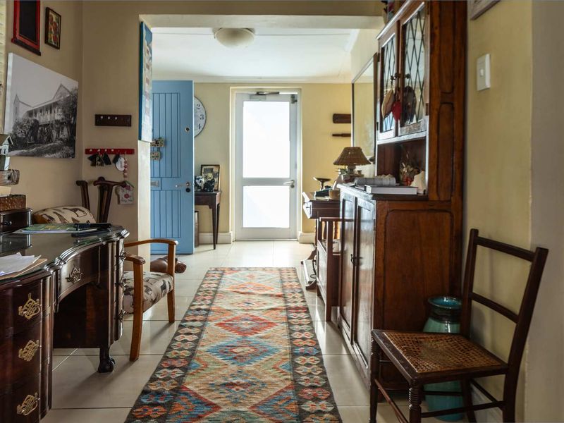 A welcoming entrance hallway featuring tiled flooring and direct access to the exterior through a glass-paneled door.