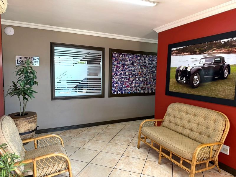 A commercial reception or waiting area featuring ceramic floor tiles, decorative wall finishes, and a frosted glass window.