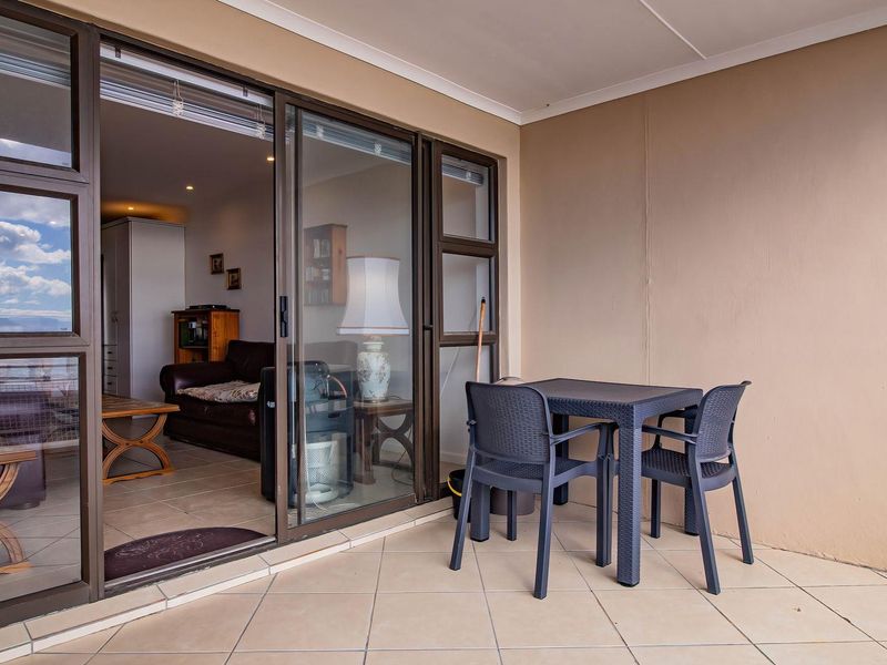 A covered balcony featuring tiled flooring and large sliding glass doors that provide seamless access to the interior living area.