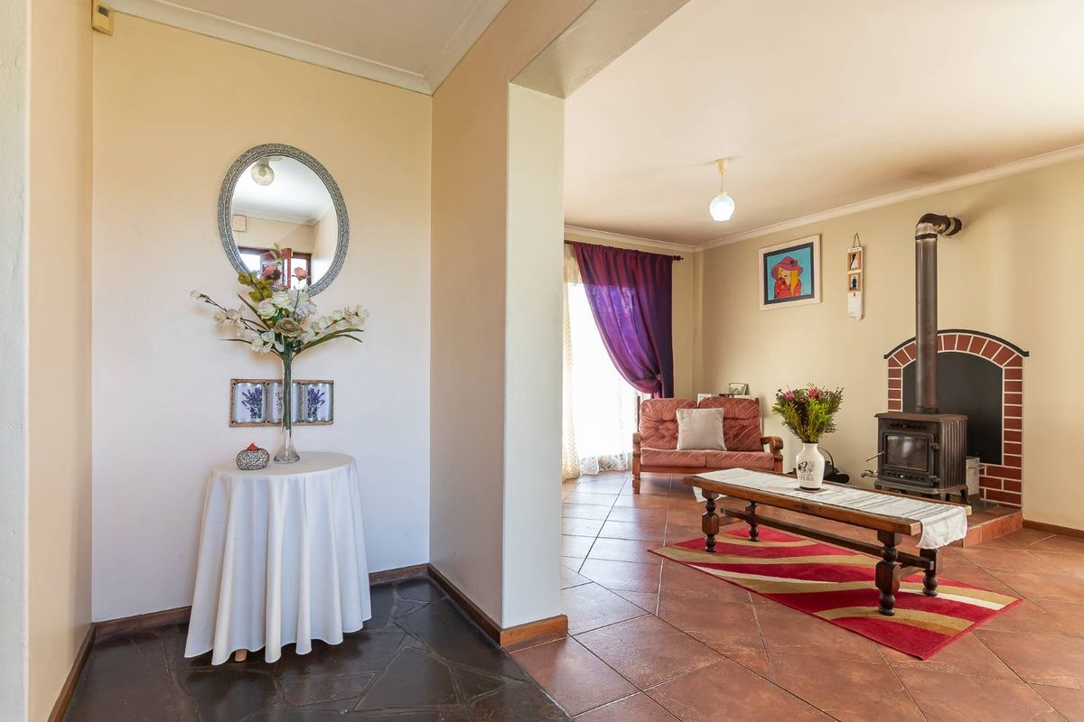 A cozy living room featuring a prominent freestanding fireplace, tiled flooring, and coved cornicing, creating a warm and inviting atmosphere.