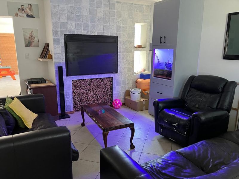 Living room featuring a tiled fireplace surround, built-in cabinetry, and ceramic floor tiles.