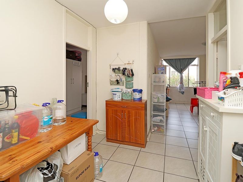 A functional hallway area featuring tiled flooring and built-in storage cabinetry, providing access to adjacent rooms within the apartment.