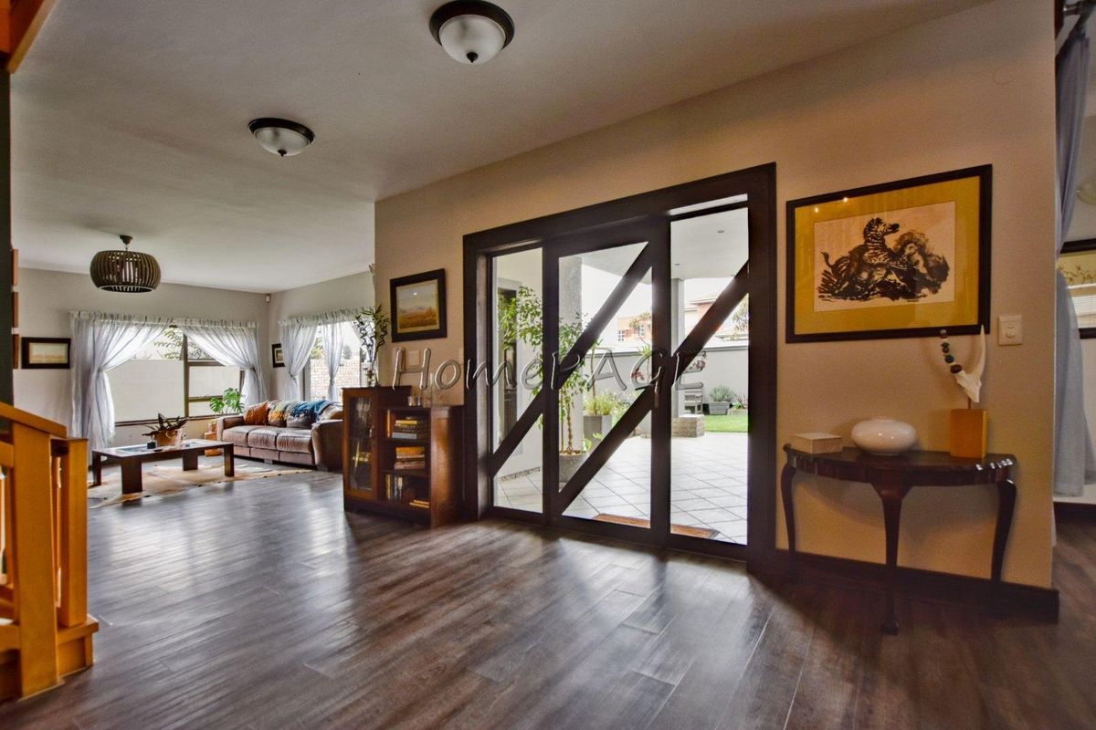 Spacious living area featuring dark laminate flooring and a large sliding glass door providing access to the outdoor patio area.