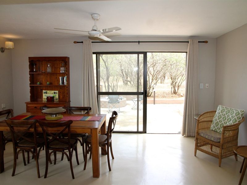 Dining area featuring polished concrete floors, a ceiling fan, and a large sliding glass door providing access to the outdoor patio.