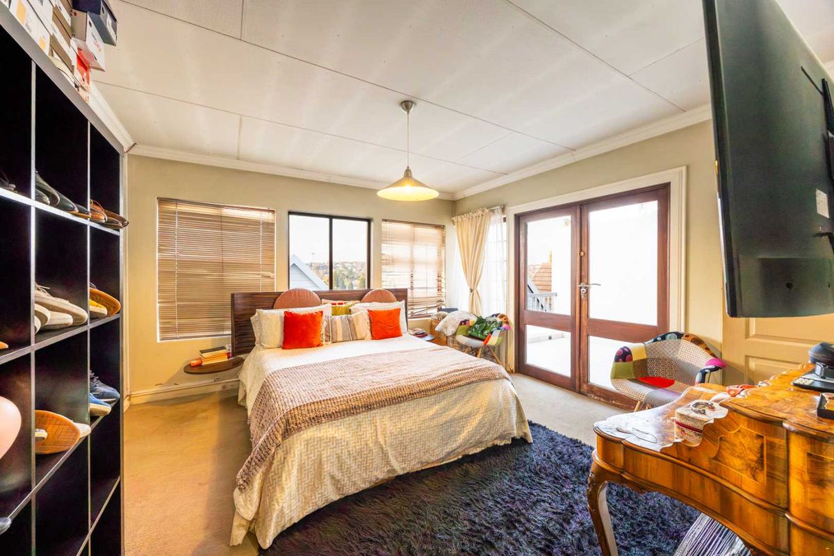 Spacious bedroom featuring carpeted flooring, a tiled ceiling, and double glass doors providing access to an outdoor area.