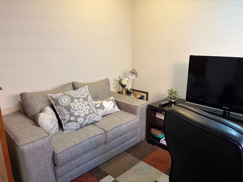 A compact living area featuring neutral wall finishes, suitable for a small lounge or media room setup.