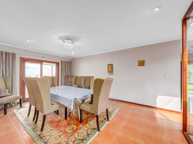 Spacious dining room featuring terracotta floor tiles, recessed lighting, and a sliding glass door providing access to the outdoor area.