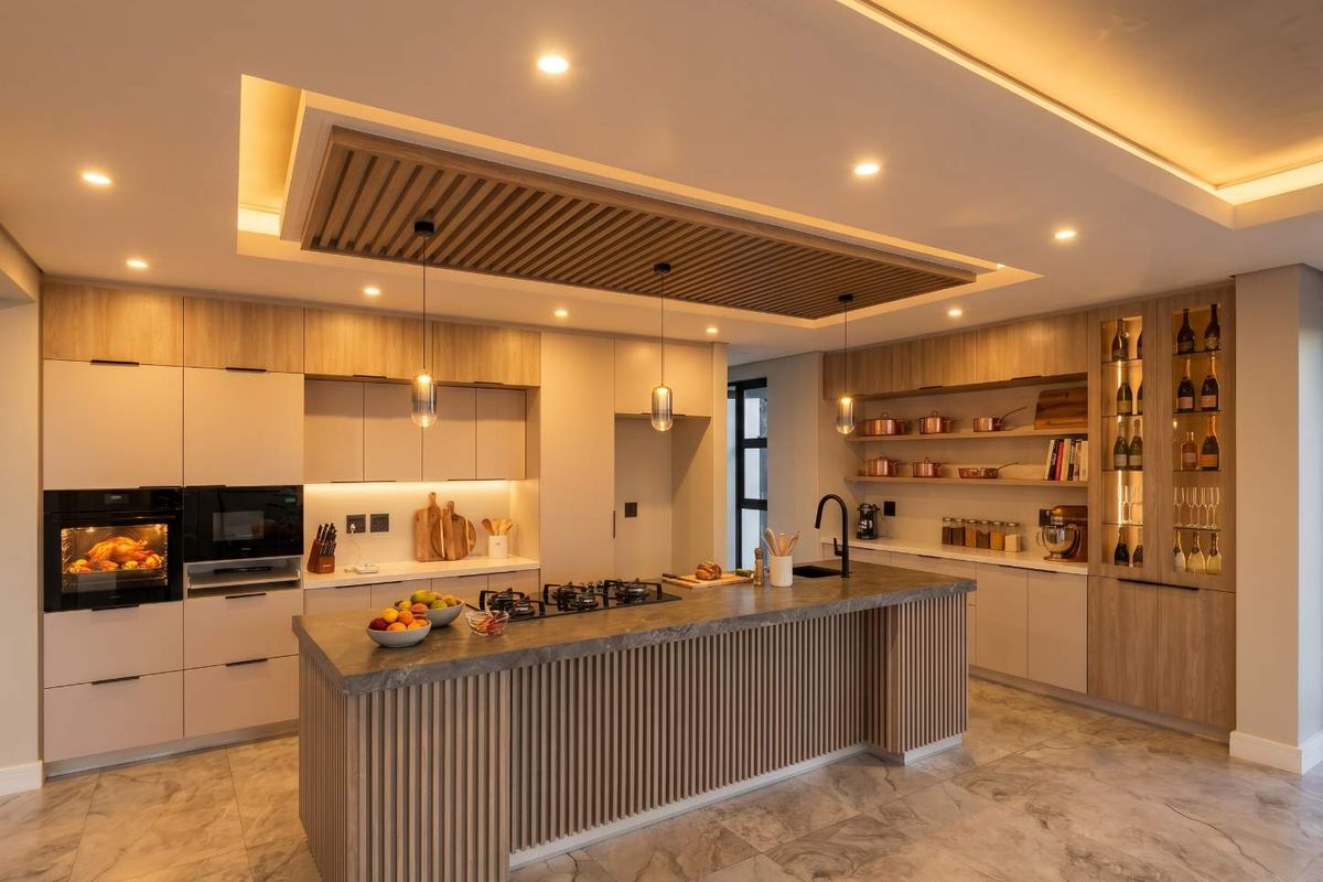 Modern luxury kitchen featuring a large central island, integrated appliances, custom slatted timber ceiling detail, and high-end cabinetry with ambient lighting.
