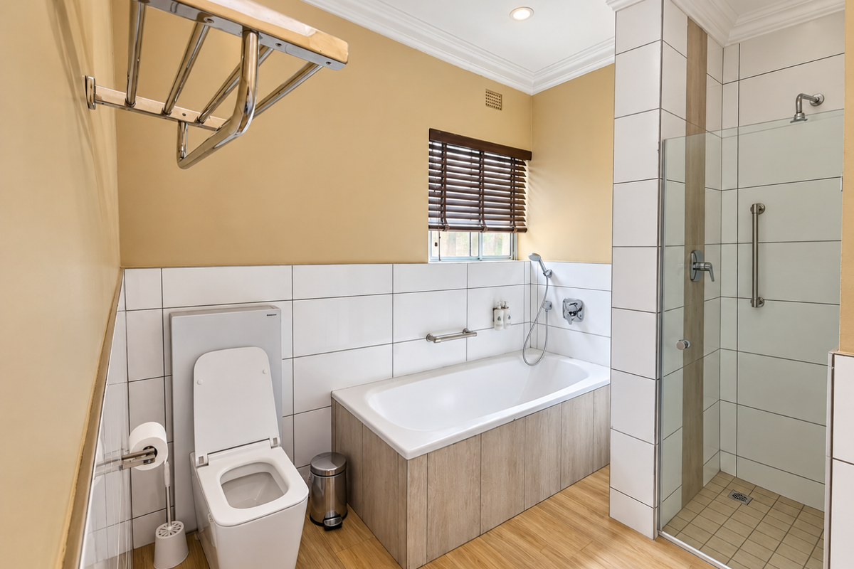Modern bathroom featuring a built-in bathtub, separate walk-in shower with glass enclosure, wall-mounted toilet, and contemporary timber-look finishes.
