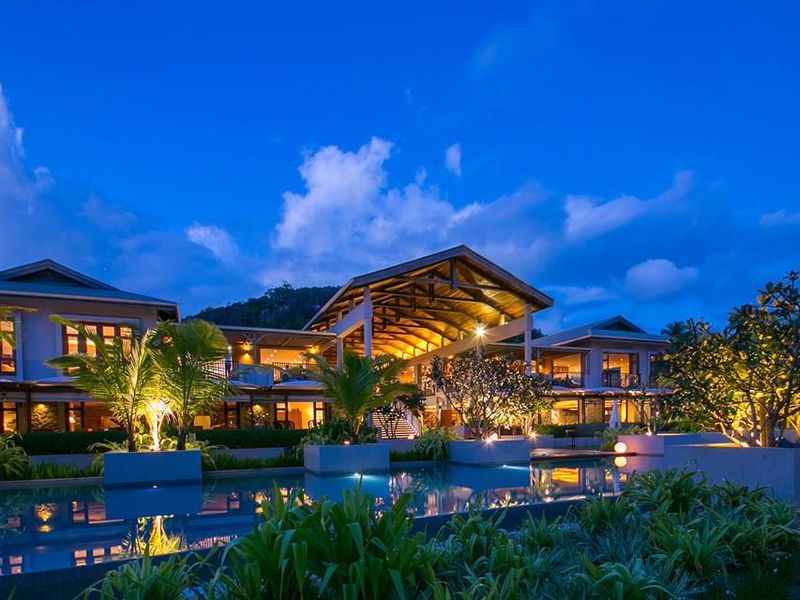 A stunning twilight view of a luxury villa featuring a large swimming pool, expansive outdoor entertainment areas, and sophisticated architectural design.
